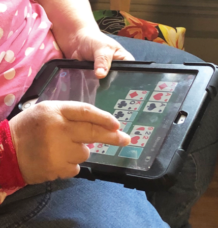 person playing solitaire on a tablet