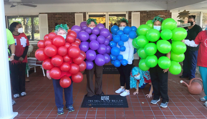 Morganfield Nursing and Rehab staff members dressed as grapes using different colored balloons