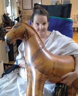 woman holding balloon horse celebrating the Kentucky Derby at Morganfield Nursing and Rehab