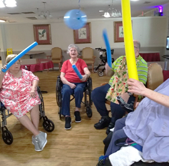 Morganfield Nursing and Rehab residents playing with pool noodles and balloons