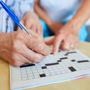 hand view only stock Canva image two people completing a crossword puzzle.